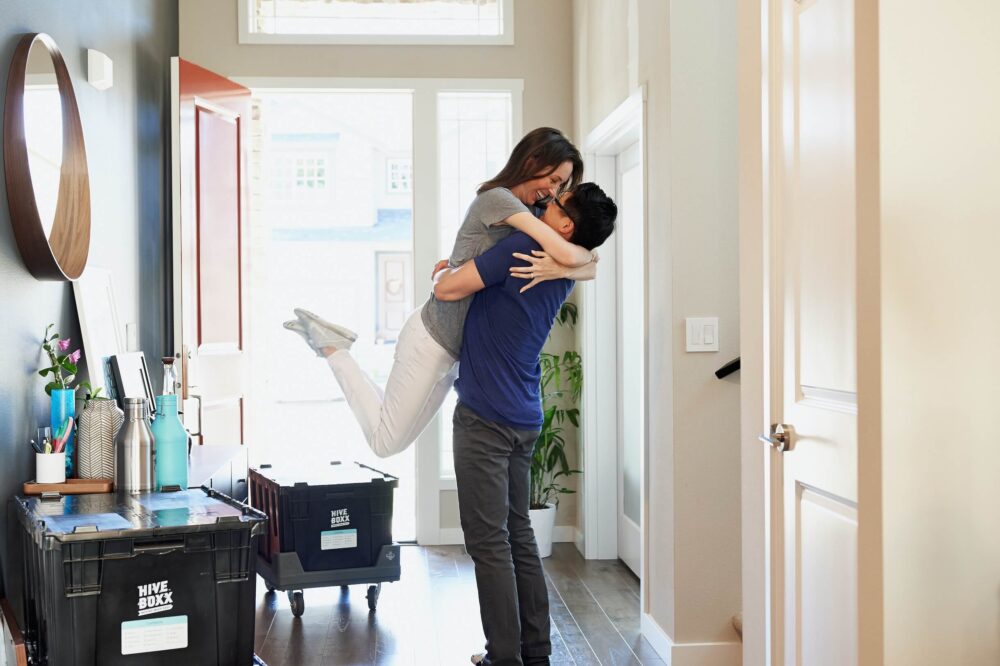 couple embrace in hallway of their new home first time buying