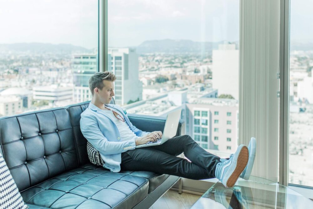 man sitting on sofa using laptop viewing stamp duty changes for buyers